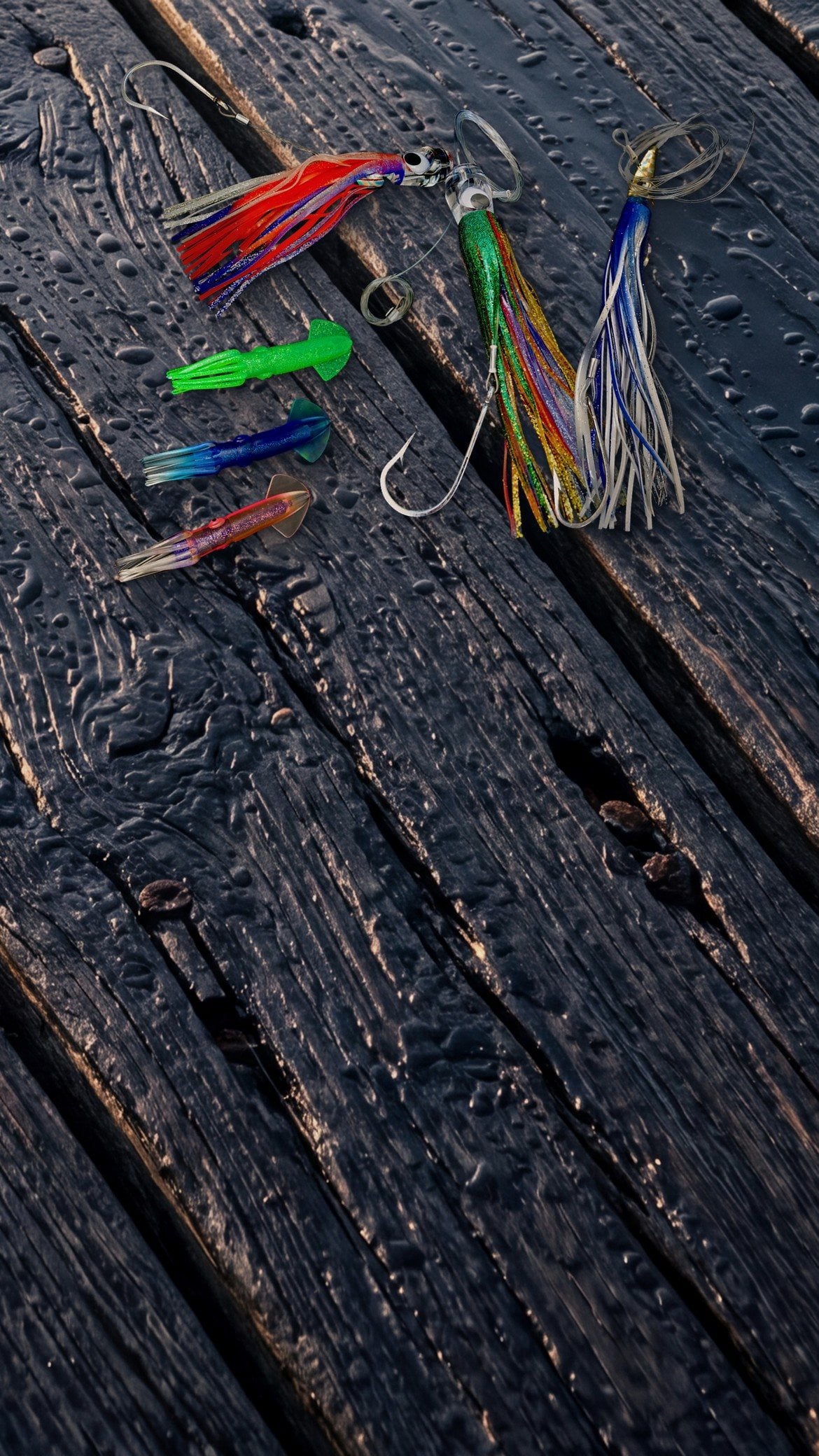 Rigged trolling skirts and squid lures from the Billy Bones shelves laid out on wet dock planks